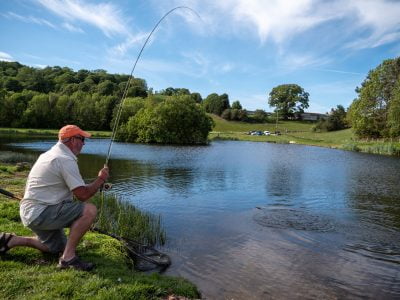 Mike netting a Wal Goch rainbowtrout Trout using a Black skinny jungle cock flash back diawl bach