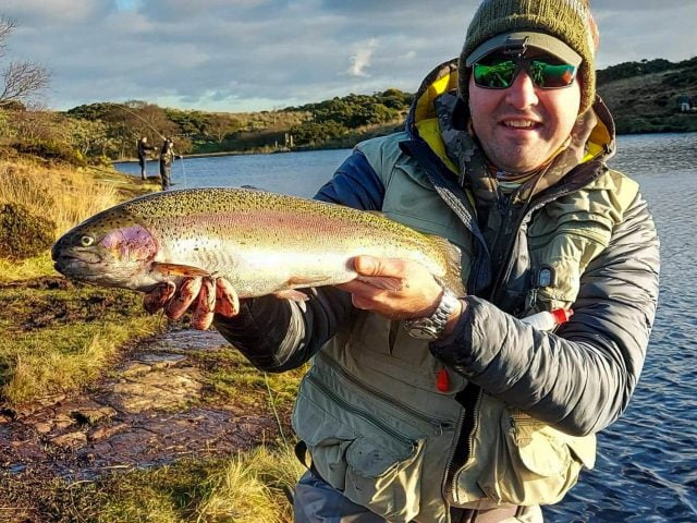 Arden Pollock with a cracking rainbow trout caught from a small water